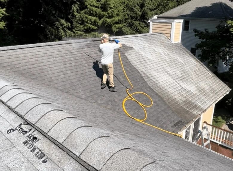 Westlake Power Washing professional cleaning and inspecting gutters on Westlake home